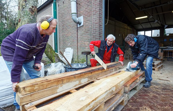 Vincent Geurts, Jan Louvenberg en Tom van Schendel (vlnr) maken in Nuland twee houten bankjes voor de wijk Boschveld in Den Bosch die later deze maand worden onthuld.