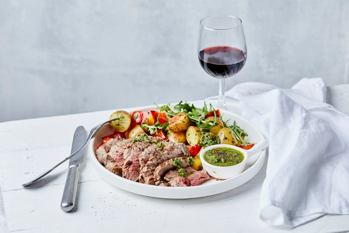 Steak with stir-fried potatoes, bell pepper and salsa verde.