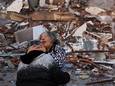 Een vrouw huilt bij het puin van een ingestort gebouw in Hatay in Turkije.