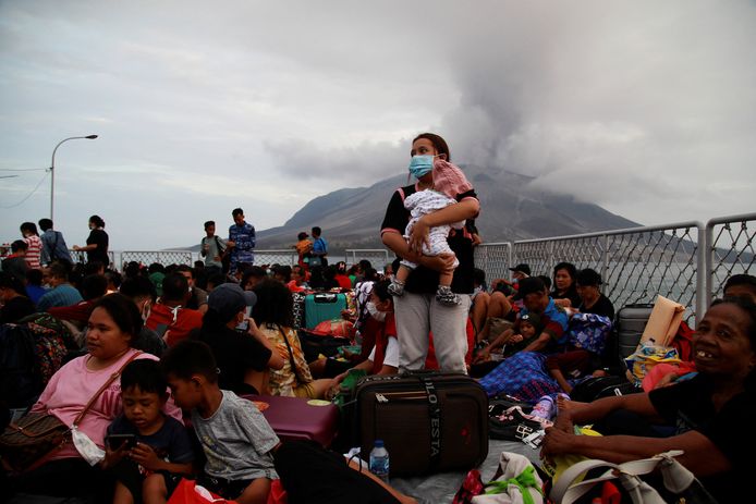 Met de vulkaan Ruang op de achtergrond worden omwonenden geëvacueerd op een Indonesisch oorlogsschip na de uitbarsting van dinsdag.