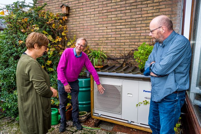 Dick Biesta (midden) geeft tijdens de Duurzame Huizenroute het echtpaar Van der Vlist uitleg over de werking van zijn warmtepomp. Het apparaat levert hem een forse gasbesparing op en verwarmt zijn huis.