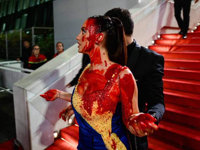 Vrouw gekleed in Oekraïense kleuren voert actie met nepbloed op rode loper in Cannes 