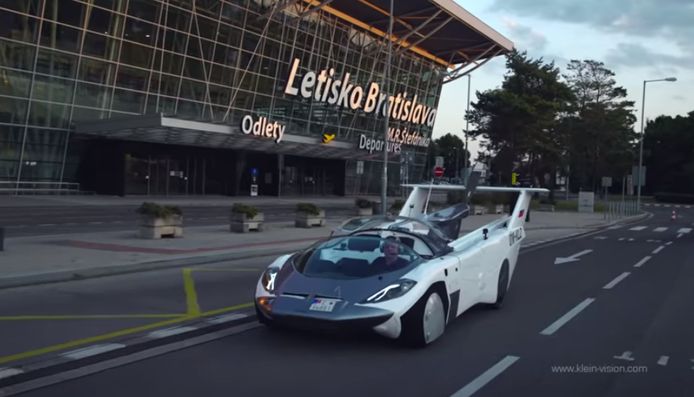 De AirCar weer met de wielen op de grond, rijdend voorbij de luchthaven in Bratislava.