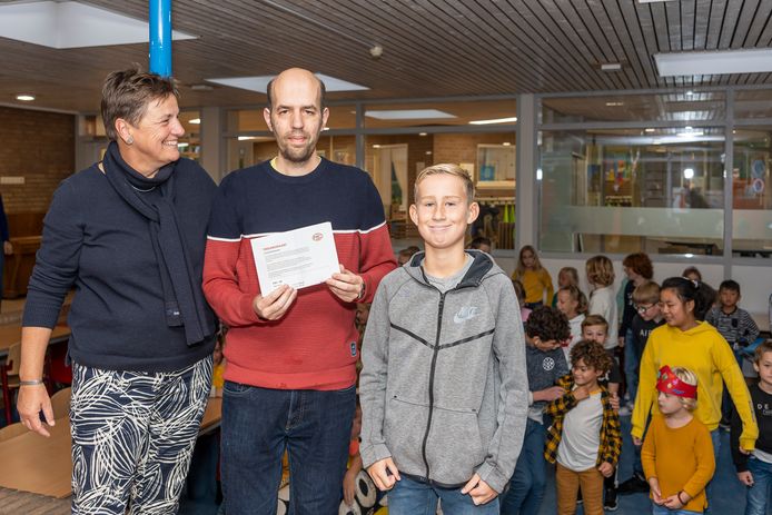 Conciërge Sander Vreeke (m) kreeg kaartjes voor de wedstrijd PSV-AZ voor zijn 20-jarig jubileum bij basisschool Stapelhof in Renesse. Naast hem schooldirecteur Ingrid Bijlsma en Fedde Raats die het cadeau overhandigde namens alle leerlingen en leerkrachten.