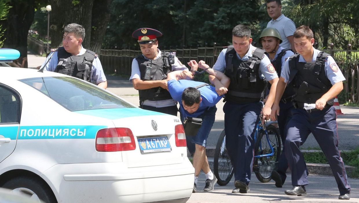 De Kazachse politie arresteert een van de verdachten van de schietpartij op het politiebureau in Alma-Ata. Beeld epa
