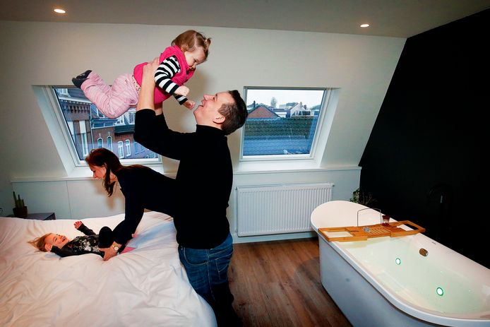 Doortje en Maarten samen met hun twee dochtertjes in hun ruime slaapkamer met ligbad.