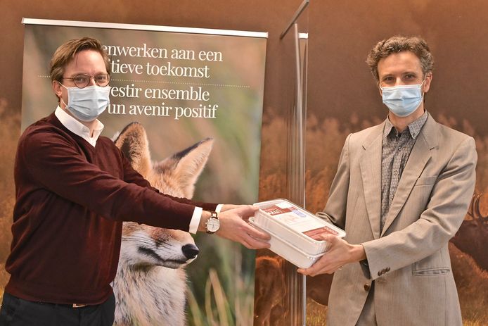 Lysander Werbrouck van JLLC overhandigt enkele wildburgers aan de coördinator van de Voedselbanken.