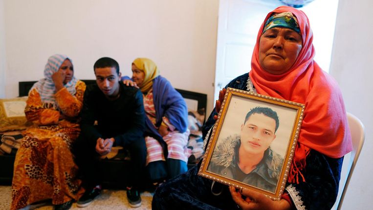 De moeder van de vermoedelijke aanslagpleger toont een portret van haar zoon. Beeld epa