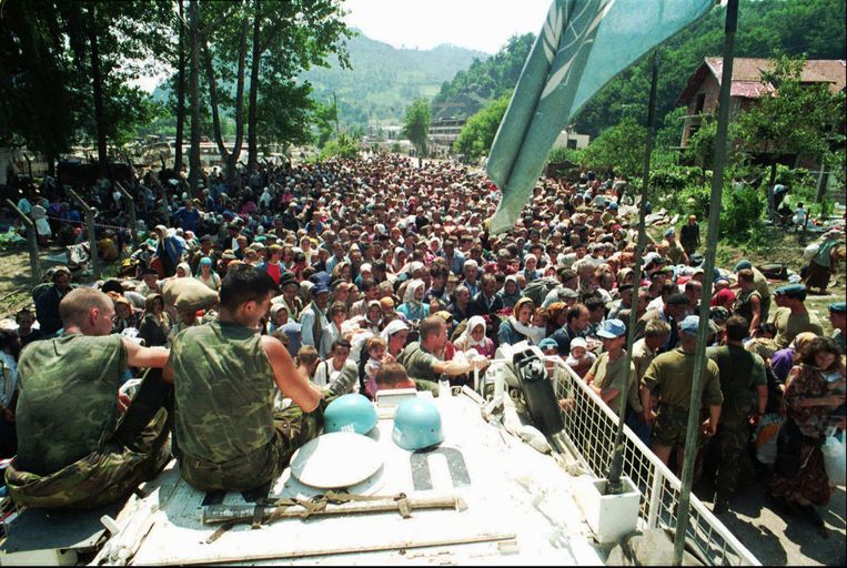 13 juli 1995. Massa's vluchtelingen uit Srebrenica stromen toe in Potocari. Nederlandse blauwhelmen kijken toe. Even later namen de Servische strijders alle mannen mee. Beeld © AP