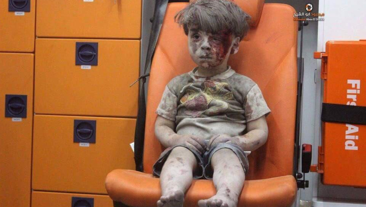 Omran Daqneesh zit in shock in de ambulance nadat hij gewond raakte bij een luchtaanval in Aleppo. Beeld Twitter: @rafsanchez