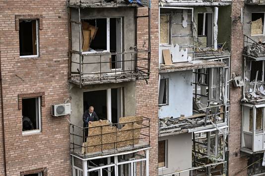Een man op het balkon van zijn beschadigd appartementsgebouw in Bakhmut in de Donbas.