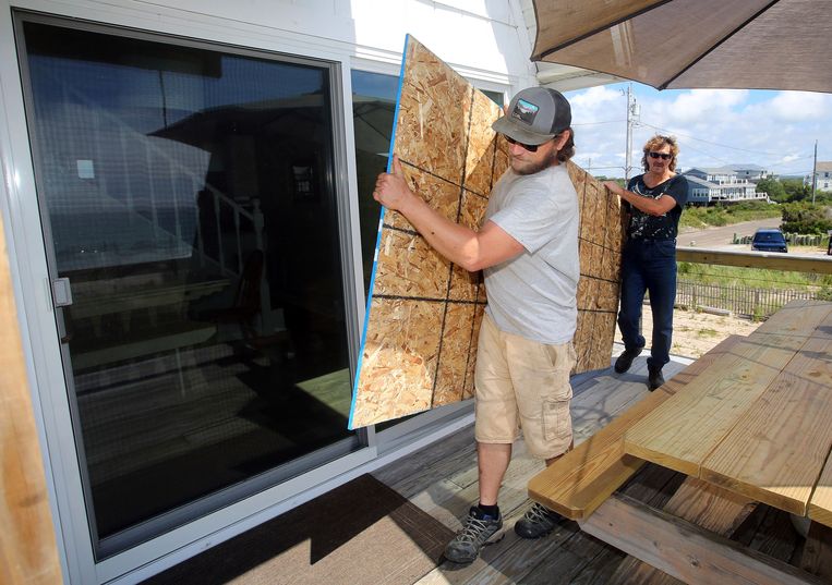 Een glazen schuifpui van een huis in Charlestown, de VS, krijgt bescherming. Beeld AP