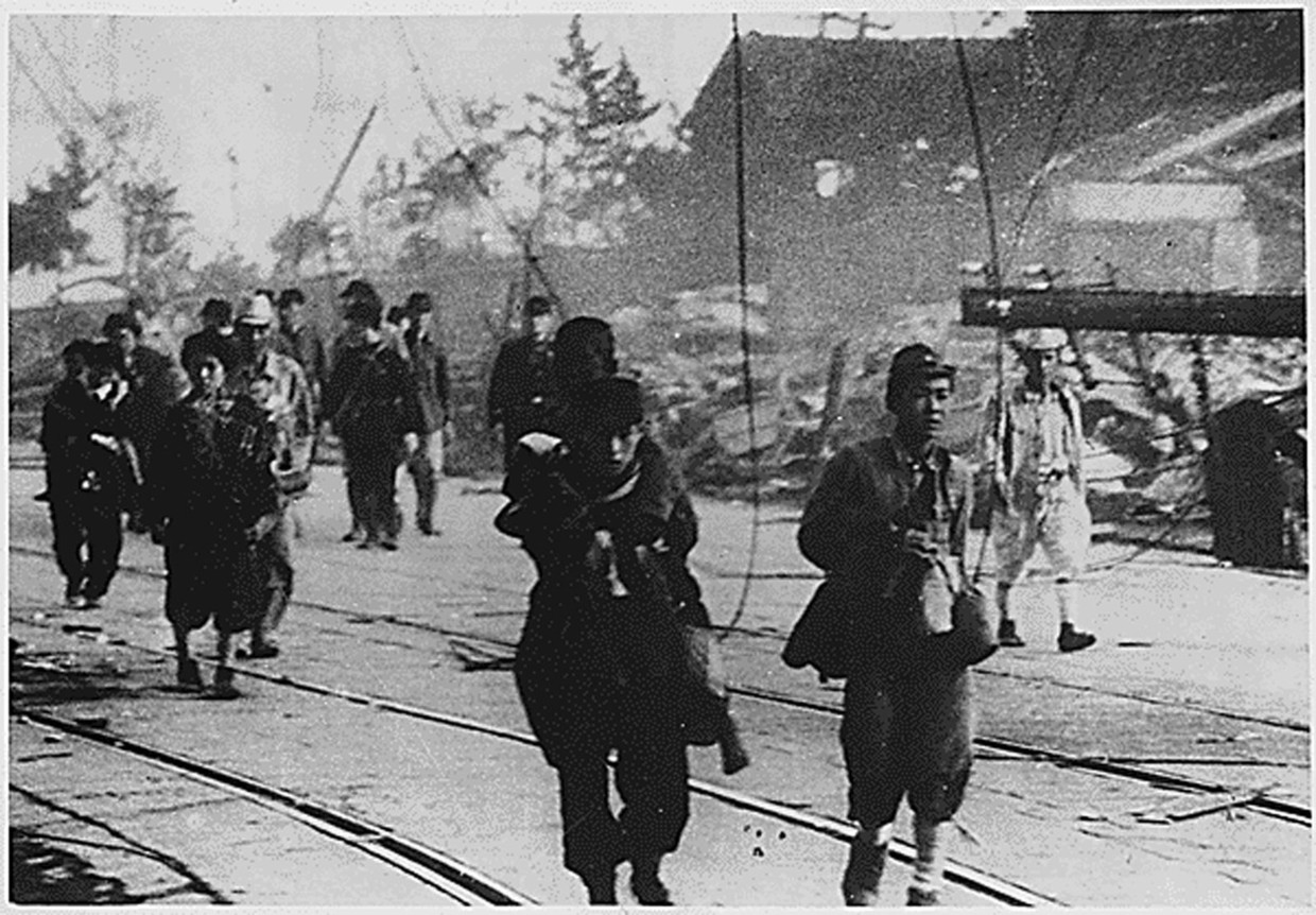 Overlevenden lopen over straat in Nagasaki, Japan. Beeld anp