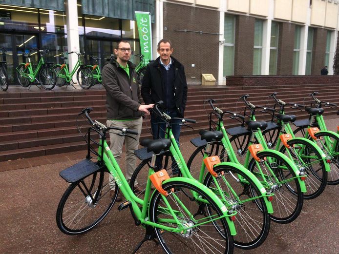 Bernard De Groote, CEO van Mobit (links) en schepen van mobiliteit Michaël Dhoore (rechts) bij de deelfietsen.