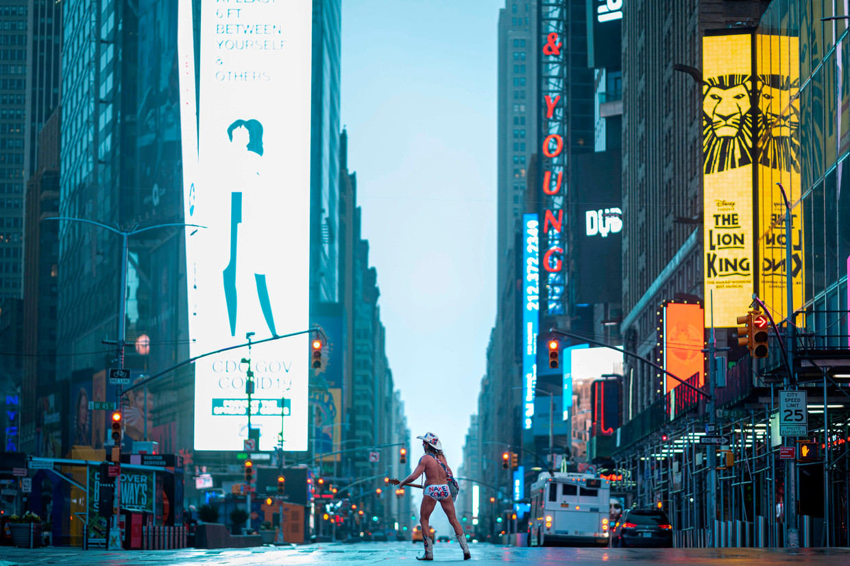 Times Square in New York is verlaten, op een straatmuzikant na die bekendstaat als The Naked Cowboy.  Beeld AFP