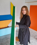 Kunstenares Nia Maertens in haar atelier aan de NCBlaan met haar schildersdoeken die diverse vormen hebben.