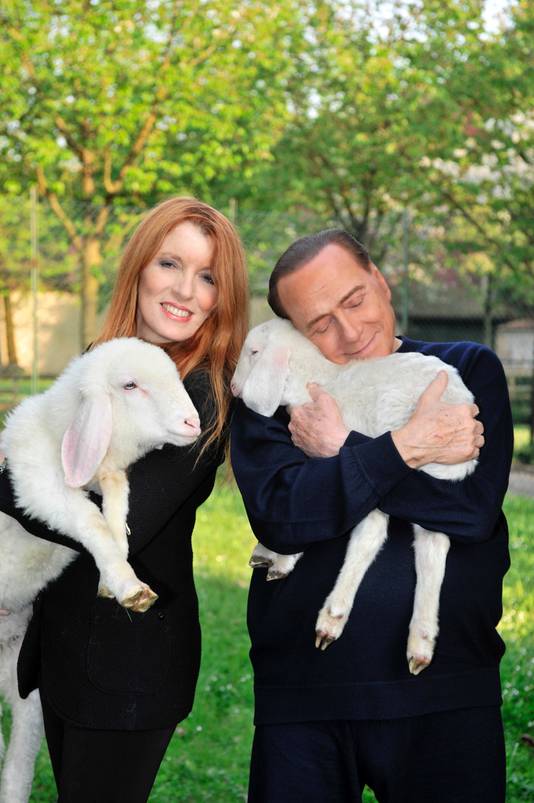 Silvio Berlusconi knuffelt met een lammetje en roept mensen op vegetarisch te eten tijdens Pasen. Naast hem Michela Vittoria Brambilla, een Italiaanse dierenactivisten.