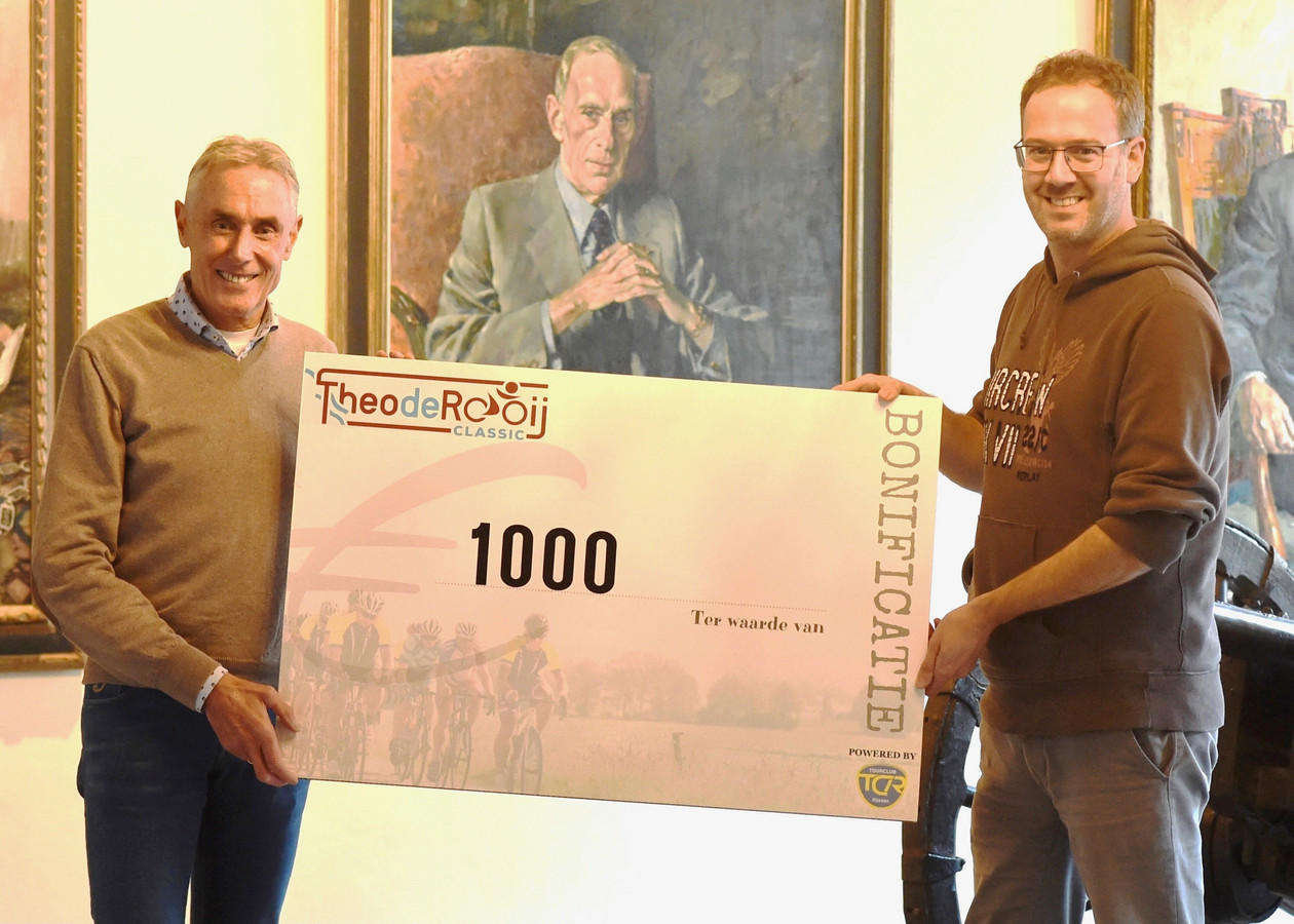 Theo de Rooij overhandigt een cheque van 1000 euro aan Rogier Veltrop.