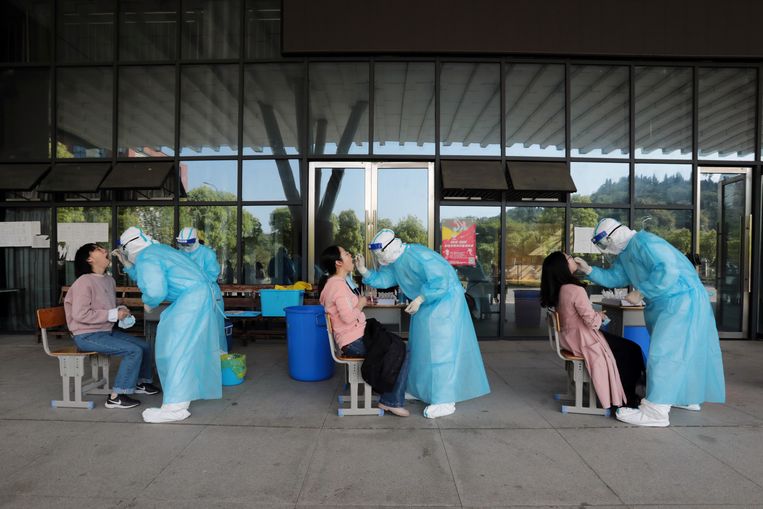Verpleegkundigen nemen speekselmonsters van middelbare schoolleraren in Yichang, China.  Beeld REUTERS