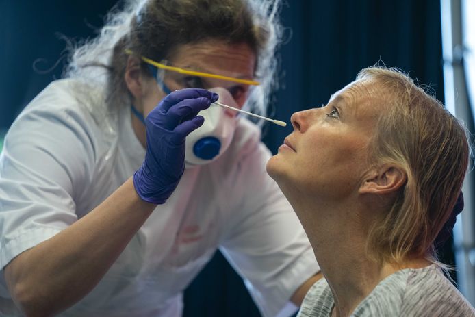 Een zorgmedewerker wordt getest op het coronavirus door medewerkers van de GGD Amsterdam.