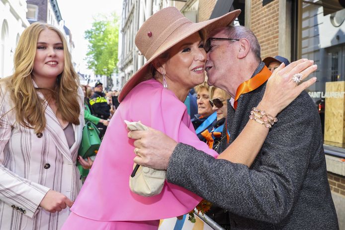 Prinses Amalia, koningin Máxima die een kus krijgt tijdens Koningsdag in Maastricht. Na twee stille coronajaren vieren Nederlanders weer als vanouds Koningsdag.