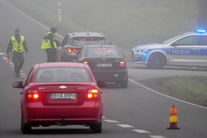 Poolse militaire politieagenten controleren auto's bij de grens met Belarus. Daar zitten duizenden migranten klem die via Belarus illegaal de EU proberen binnen te komen.
