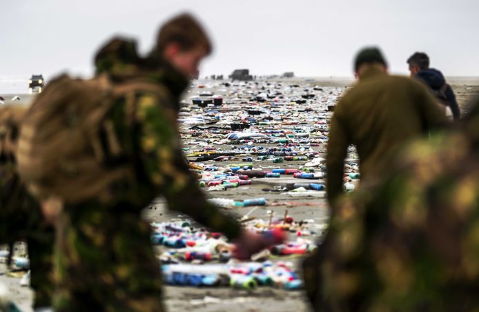 Militairen ruimen de spullen op die op het strand zijn aangespoeld.