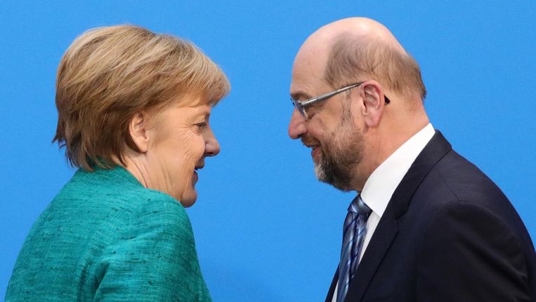 Angela Merkel en Martin Schulz komen aan bij de presentatie van hun gezamenlijke regeerakkoord. Beeld Kay Nietfeld/DPA