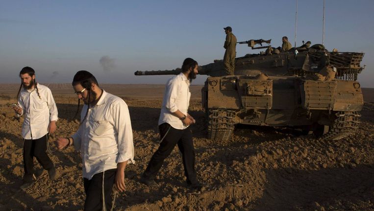 Orthodoxe joden bij tanks van het Israëlische leger op de grens met Gaza. Beeld reuters