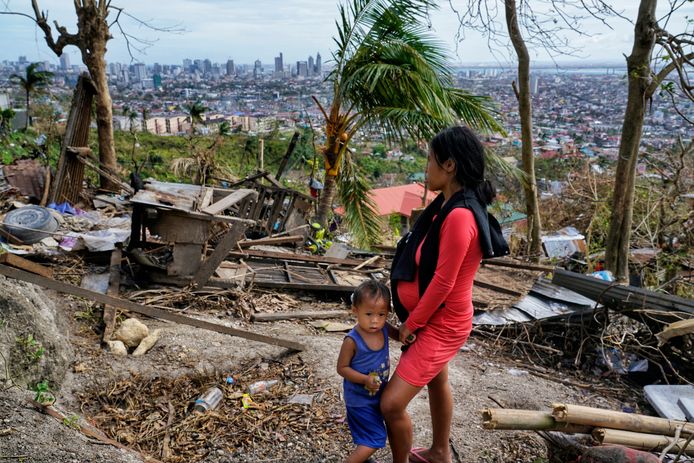 Alona Nacua met haar zoontje terwijl ze op eerste kerstdag naar hun beschadigde huis kijken in Cebu City, centraal in de Filipijnen.