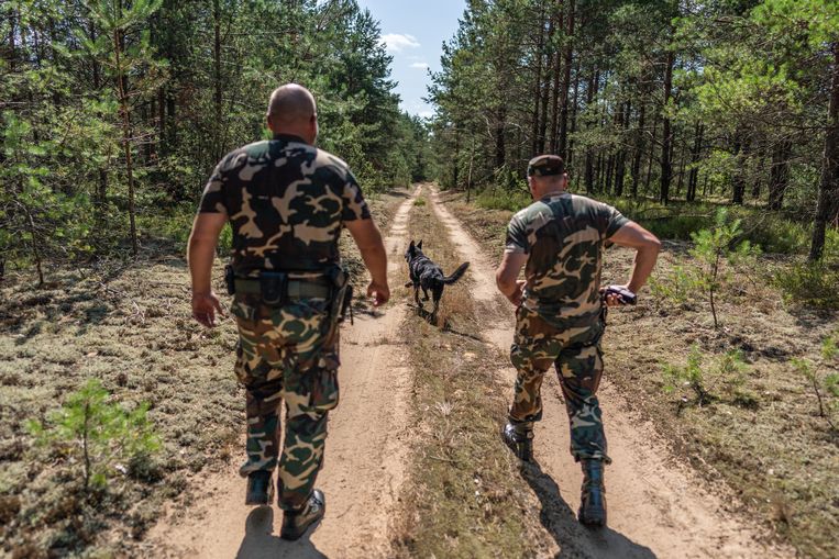 Bewapende leden van de Litouwse grensbewaking controleren de grens met Belarus. Beeld Joris van Gennip