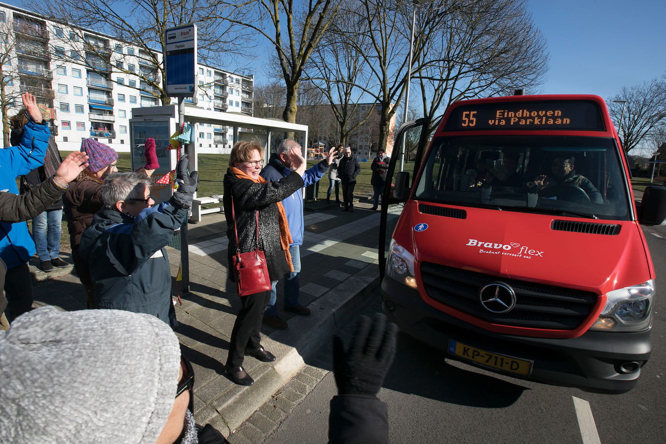 Wethouder Jannie Visscher (met rode tas) en diverse actievoerders verwelkomen de alternatieve bus bij de halte aan de Pagelaan.
