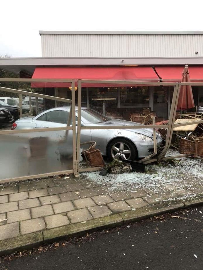 De wagen kwam tot stilstand op het terras van de brasserie.