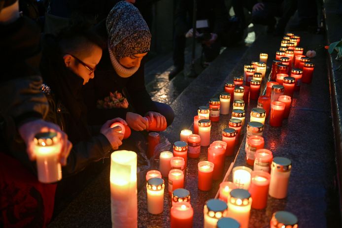 Mensen steken kaarsen aan ter herdenking van de slachtoffers aan het stadhuis in Kassel.
