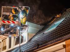 Brandweerlieden klimmen langs de dakpannen omhoog om Veldhovens vuur te blussen