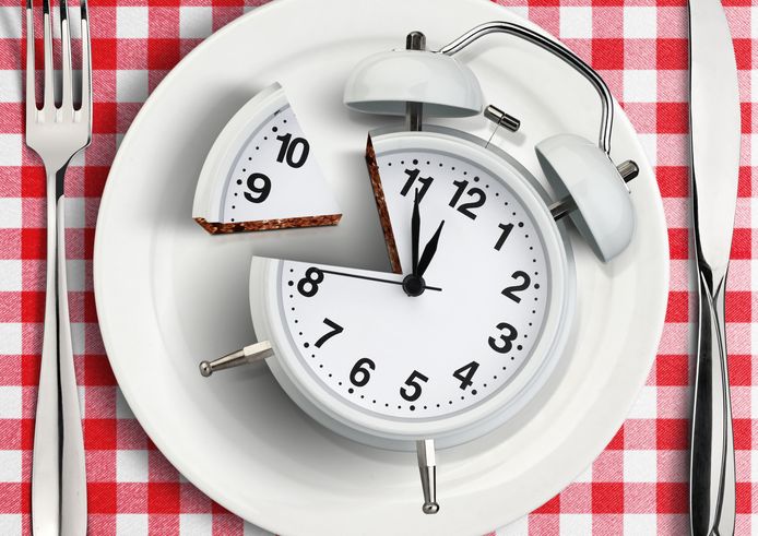Time to eat concept, cut clock on plate