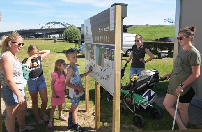 Tigo uit Vianen bekijkt het bord bij de Plas Middelwaard, waarop de plannen voor nieuwe speeltoestellen aan het strandje worden toegelicht.