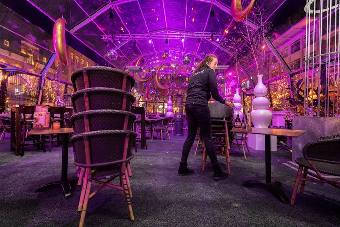 Lieke van de Meulengraaf verwijdert zaterdagavond na sluitingstijd enkele stoelen uit de tent van grand-café Centraal op de Markt in Eindhoven. De inrichting moest overal aangepast om te voldoen aan de 1,5 meterregel.