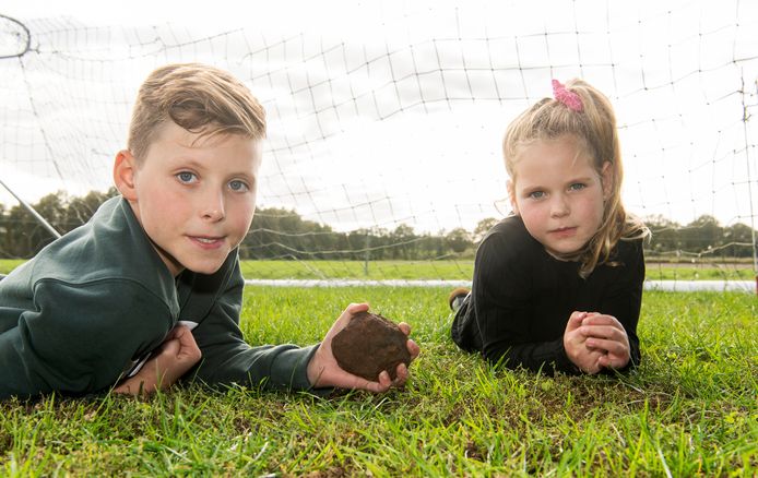 Jans Klein Gebbink met de bijzondere steen die vlak bij hem neerkwam op het grasveldje bij de boerderij. Naast hem zijn zus Jula.