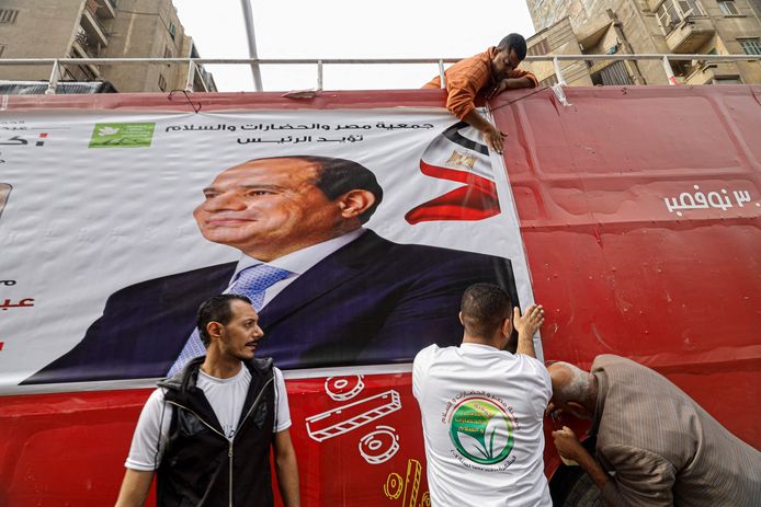 Aanhangers van de Egyptische president Abdel Fattah al-Sisi hangen een verkiezingsposter op.