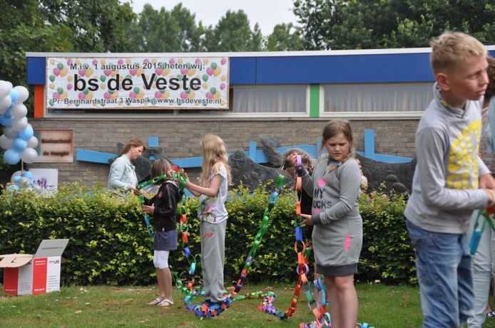 Kinderen leggen samen met de leerkrachten een ketting van papier rond de hele school