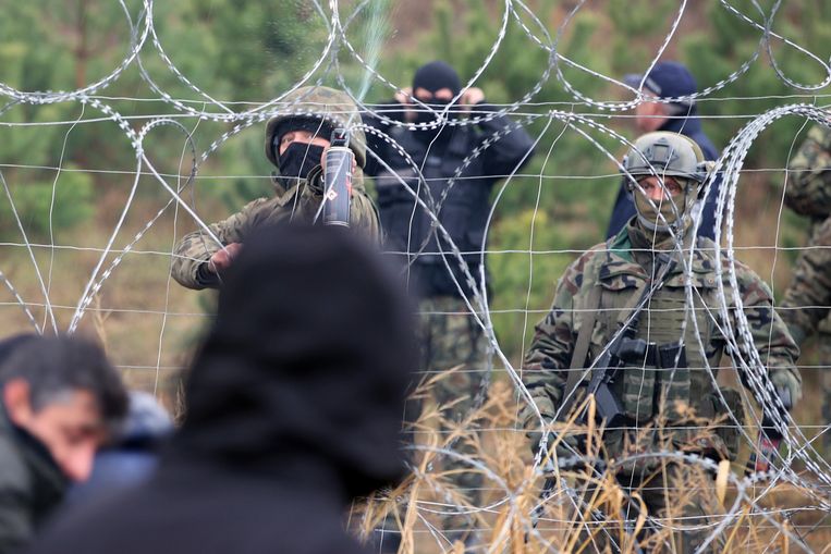 Poolse grenswachten zijn ingezet om te voorkomen dat de honderden migranten de grens oversteken. Beeld Leonid Shcheglov/AP