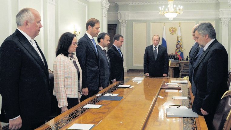 President Poetin (m) en leden van zijn regering houden een minuut stilte voor de slachtoffers. Beeld ap