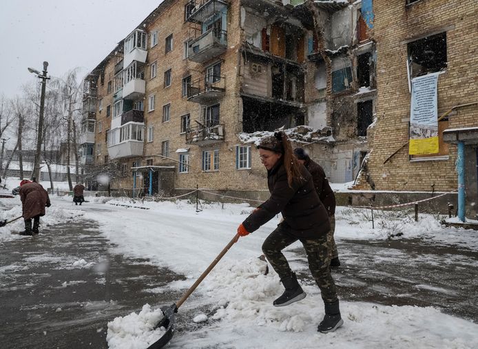Tetiana Reznychenko ruimt sneeuw voor haar verwoeste flat in Horenka.