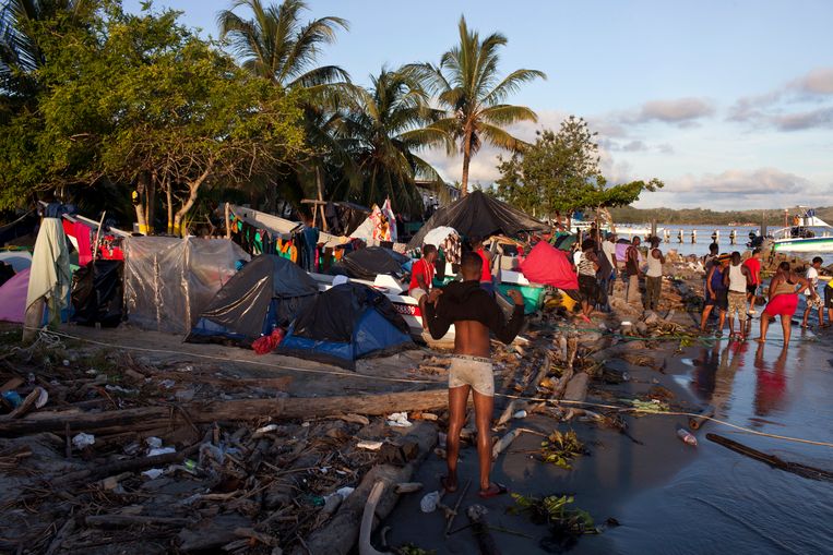 Lekkende tentjes moeten migranten de nacht doorhelpen op het strand van Necocli. In het stadje zelf verblijven al 14.000 migranten. Beeld Carlos Villalon