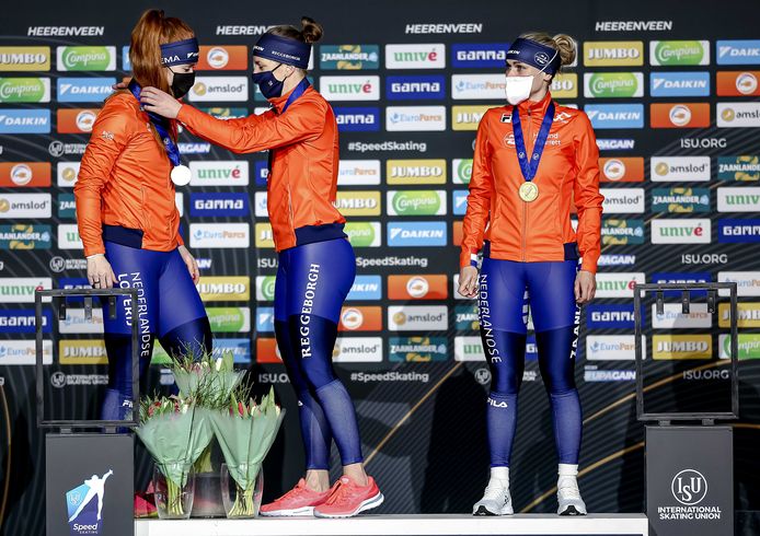 Antoinette De Jong, Ireen Wüst en Irene Schouten met mondkapje tijdens de medaille-uitreiking van de ploegenachtervolging.