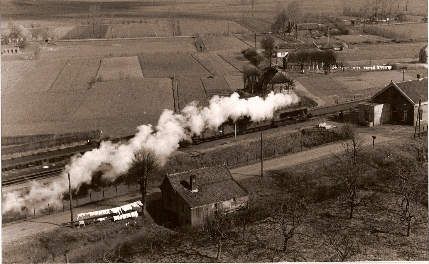 De stoomtrein passeert Geffen in 1948. Deze foto is gemaakt vanuit de kerktoren. Uiterst rechts het station dat in 1971 werd gesloopt.