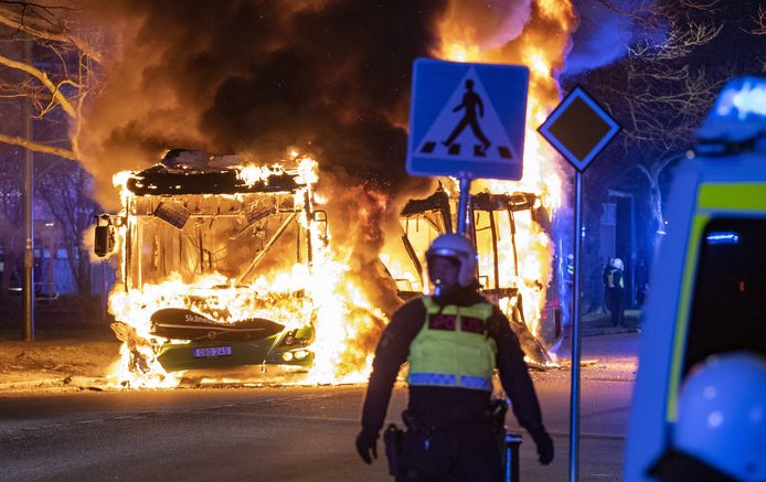 Polisi anti huru hara di bus kota yang menyala di distrik Rosengard di Malmö, Swedia, Sabtu malam.
