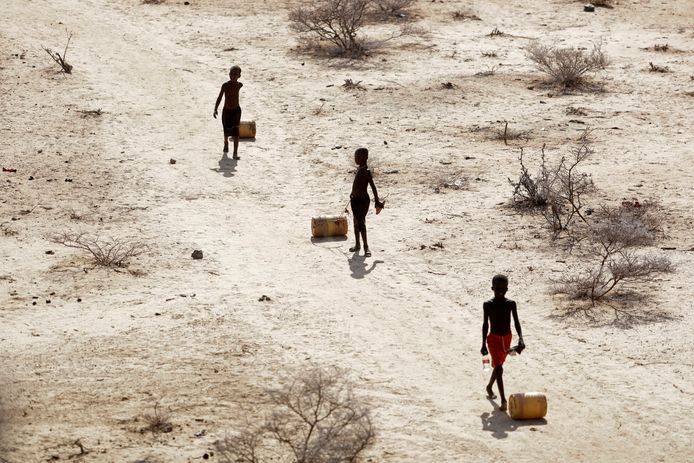 Boys carry water bottles after a picnic to a well outside their village of Ntabasi in Kenya.