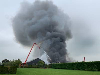 Brandweer zet alles op alles om uitslaande brand in Hedel niet over laten slaan op woonhuizen